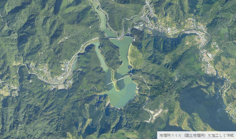 合角ダム周辺の空中写真。森の斜面がそのまま湖面へ落ち込み、湖の中ほどに合角漣大橋、北端に堰堤が見える